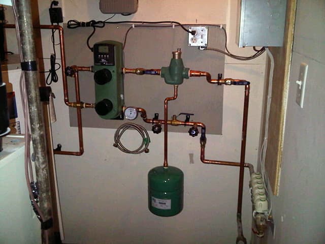 Uponor PEX radiant floor heating manifold and tubing installation.